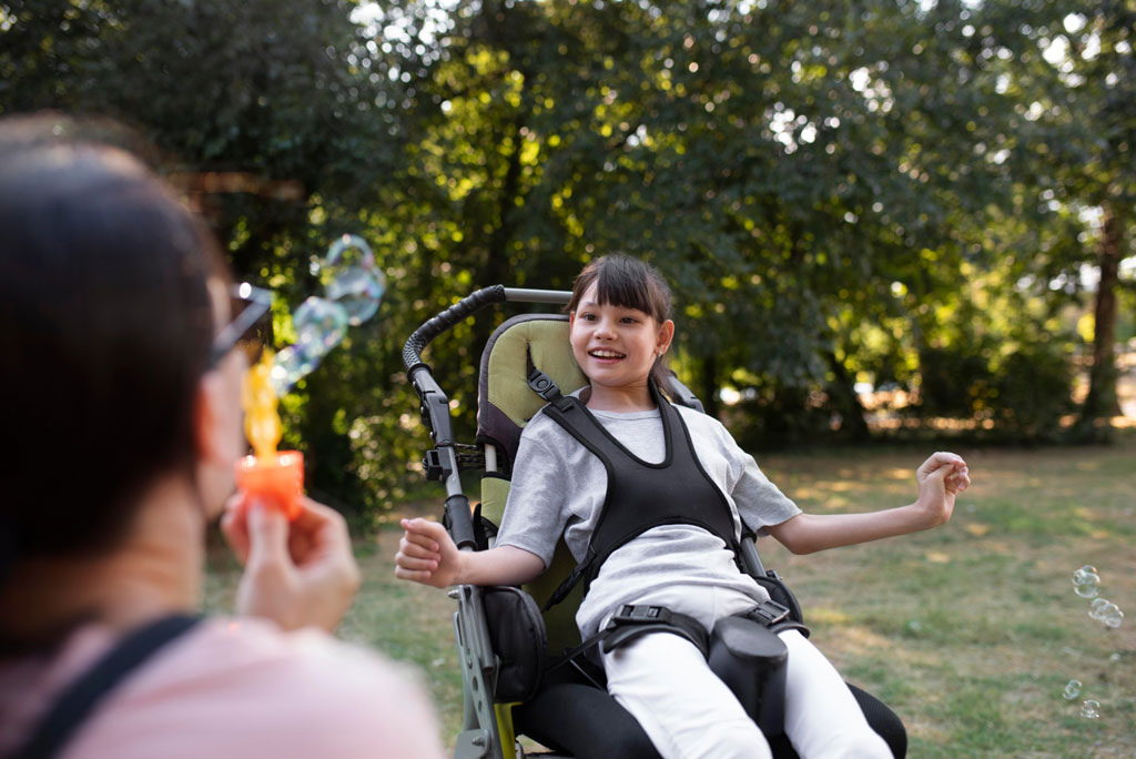 Woman blowing bubbles in front of a young girl
