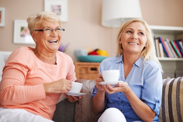 Two women smiling and drinking tea