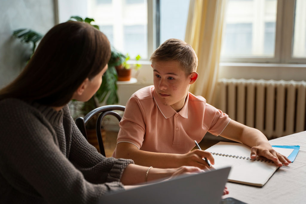 Support worker helping a young boy with homework